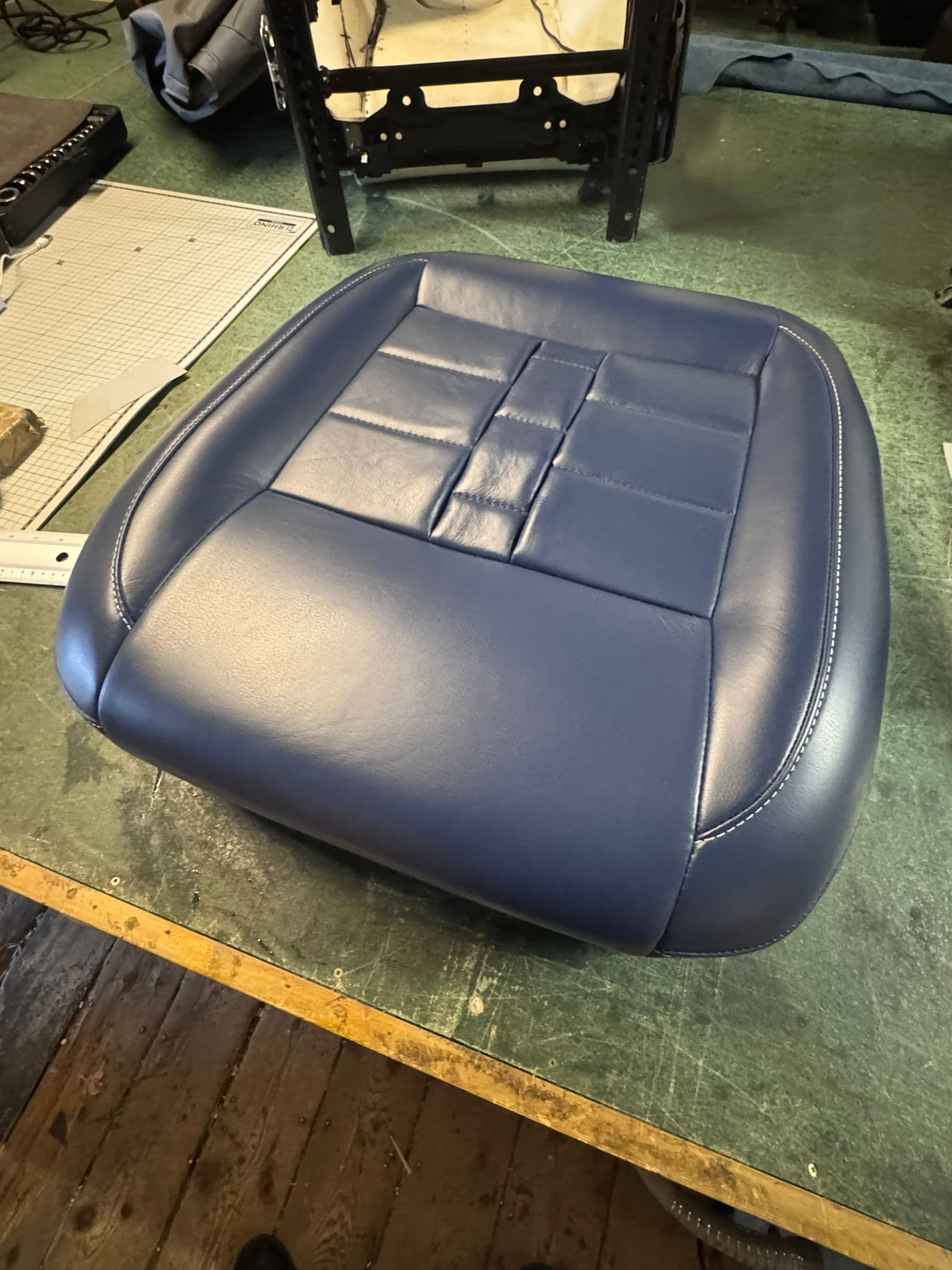 Navy seat cushion on workbench with frame visible